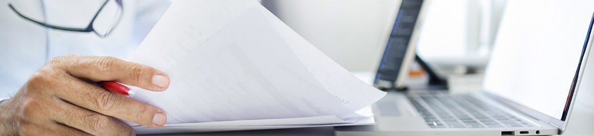 close-up of a person's hand holding a stack of papers